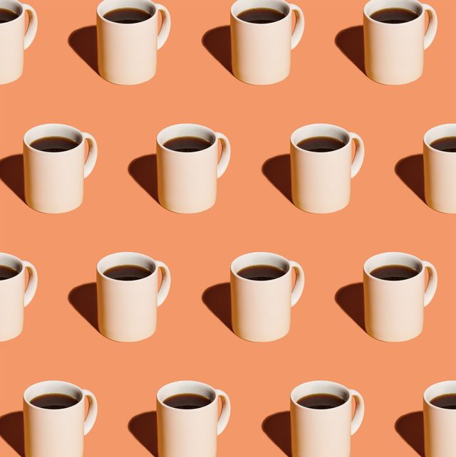 mugs of black coffee in rows against peach background