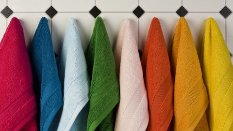 handdoeken in verschillende kleuren hangen aan haakjes naast elkaar