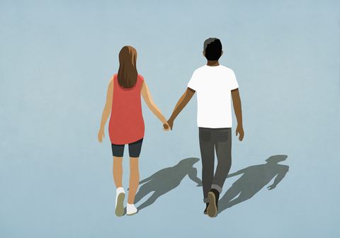 multiethnic couple holding hands and walking