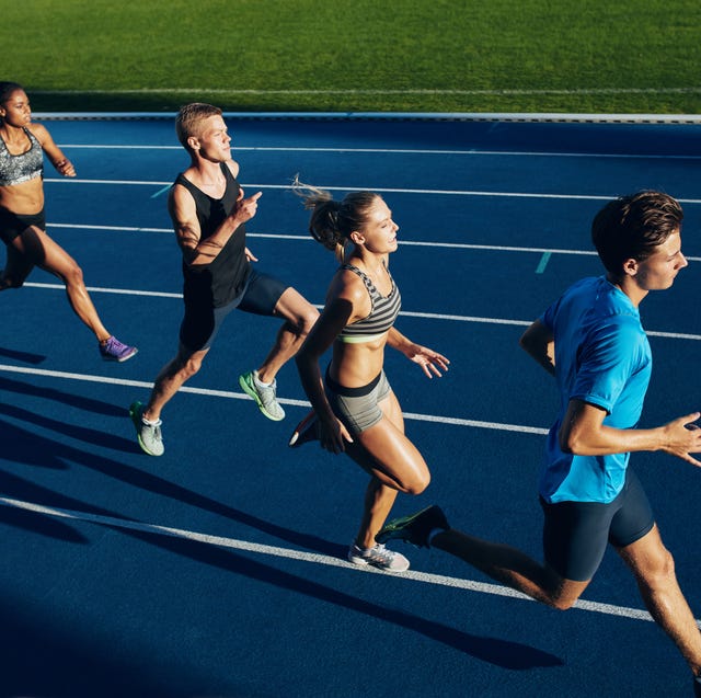 Multiracial athletes practicing running on racetrack