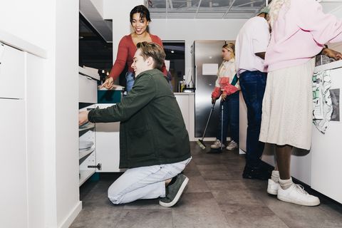 multiracial male and female students doing chores in dorm