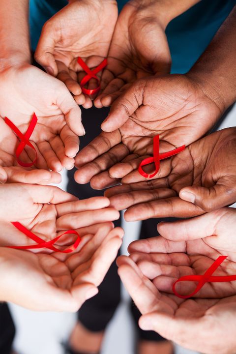 multiracial people holding red ribbon for AIDS HIV awareness