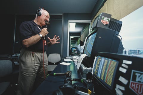 Murray Walker murray walker holds his microphone and stands in front of his desk as he commentates on a formula 1 grand prix in japan in 2001
