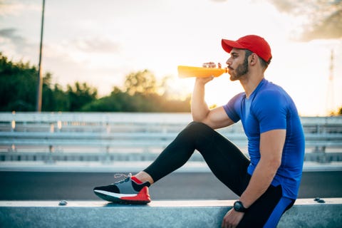 Muscular athlete resting and drinking energy drink muscular athlete resting and drinking energy drink