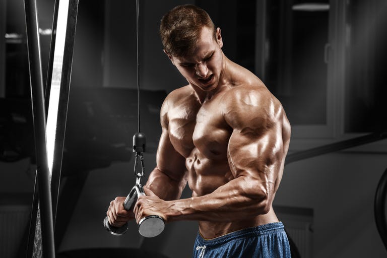 Muscular man working out in gym doing exercises, torso abs