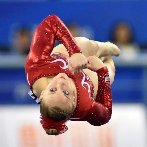 GYMNASTICS-WORLD-CHN mykayla skinner upside down on the mat in midair wearing a re sparkly leotard