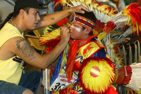 terry st john, of dakota tribe of minnesota, puts make up on the face of rick cleveland, jr, of ho chunk tribe of wisconsin, during the smithsonian's pow wow marking the continuing construction of the national museum of the american indian