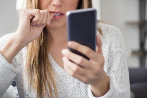 Nervous young woman using smart phone