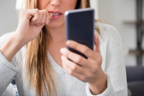 Nervous young woman using smart phone