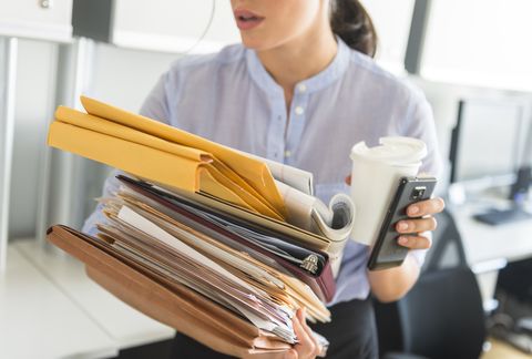 USA, New Jersey, Jersey City, Business woman holding stack of documents in office