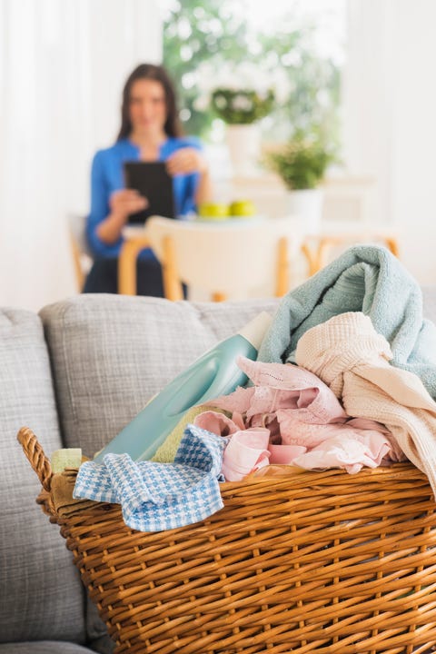 USA, New Jersey, Jersey City, Laundry basket on sofa and woman in background