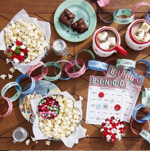 a tabletop filled with popcorn and candy and a movie ticket garland