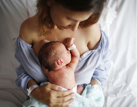 el color del bebé nada más nacer es amoratado, como el recién nacido que aparece en la foto con su madre en la cama del hospital