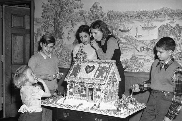 group of children 4 15 gathered around gingerbread house