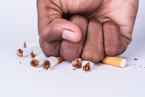 Cropped Hand Of Man Crushing Cigarette On White Background Benefits of quitting smoking 