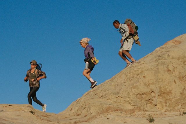 three people hiking a rocky mountain