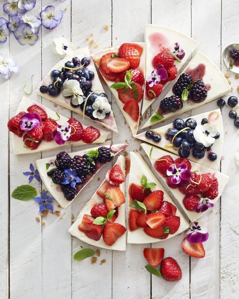 no bake cheesecake cut into slices with various berry toppings