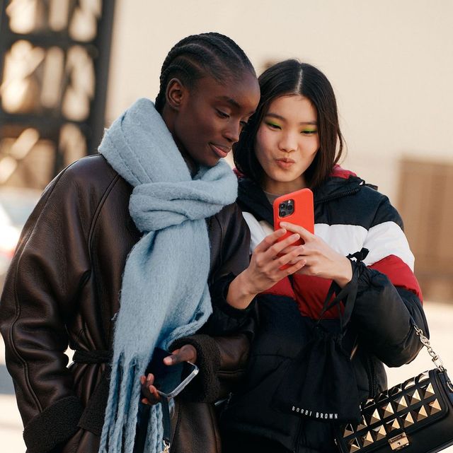 two models hold a phone in a roundup of netaporter black friday sale deals 2022