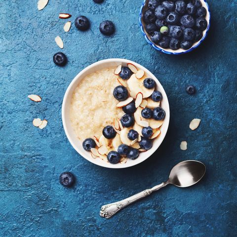 oatmeal porridge with banana and blueberry on vintage table top view in flat lay style