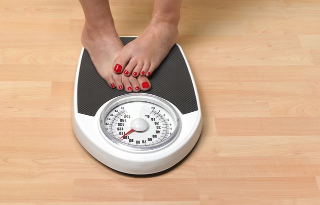 obese woman weighing herself