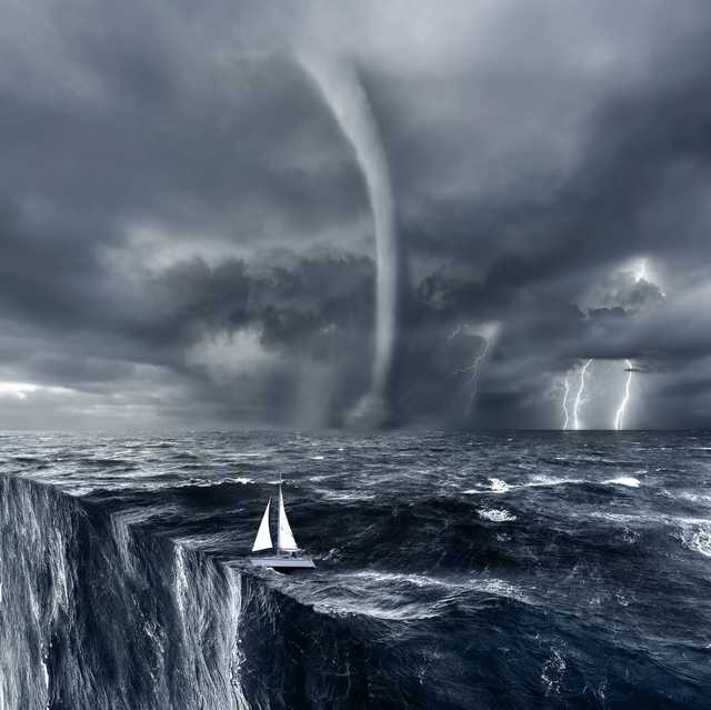 ocean with sailing boat with waterspout and hurricane