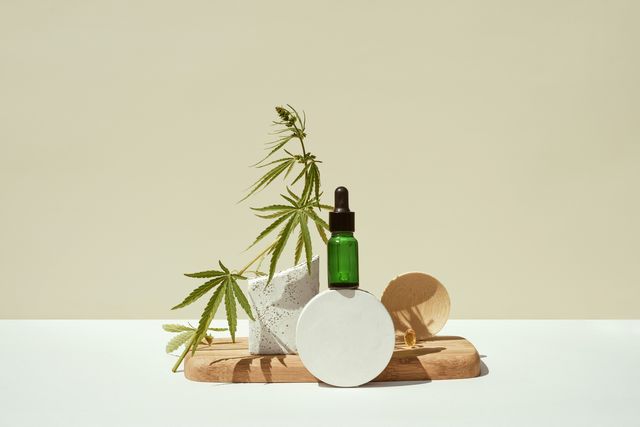 cbd oil in bottle,cannabis bush,hemp on geometric podium