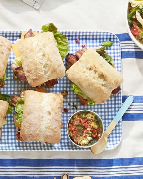 pimiento salad club sandwiches on a gingham tray on a picnic blanket