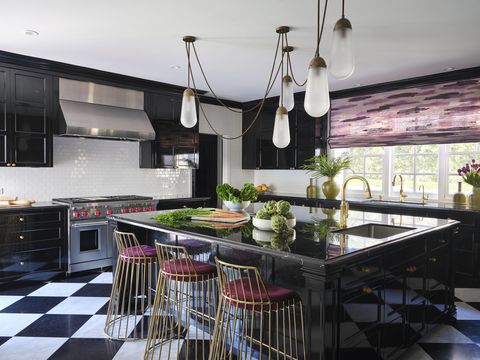 a kitchen with black and white tile floor and black cabinets