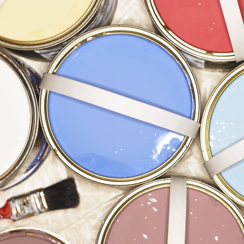 Open tins of paint on plastic covered floor, overhead view