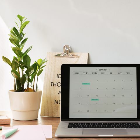 opened laptop with a calendar on desk at home office