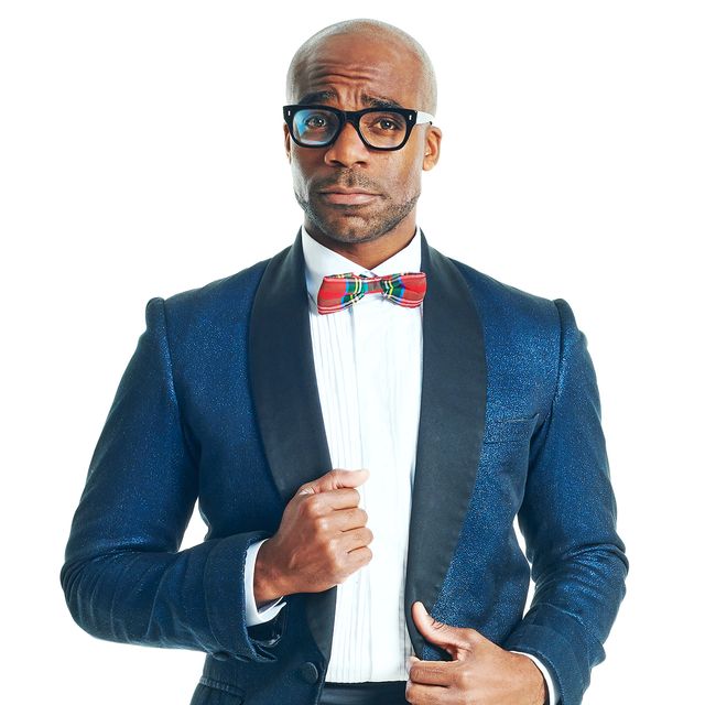 ore oduba as brad majors, wearing a suit jacket, shirt, stockings and heels in a promo photo for the rocky horror show tour