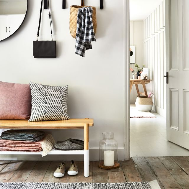 lagom, the swedish idea of having just the right amount, is captured in a perfect balance of rose tinted neutrals, wood and cosy textureshallway with grey walls, tones of pink and brushed linens add depth to a monochrome scheme, coat pegs,mirror and view into other roomwooden flooring