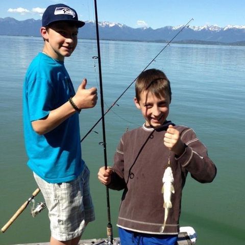 two boys fishing on a pier