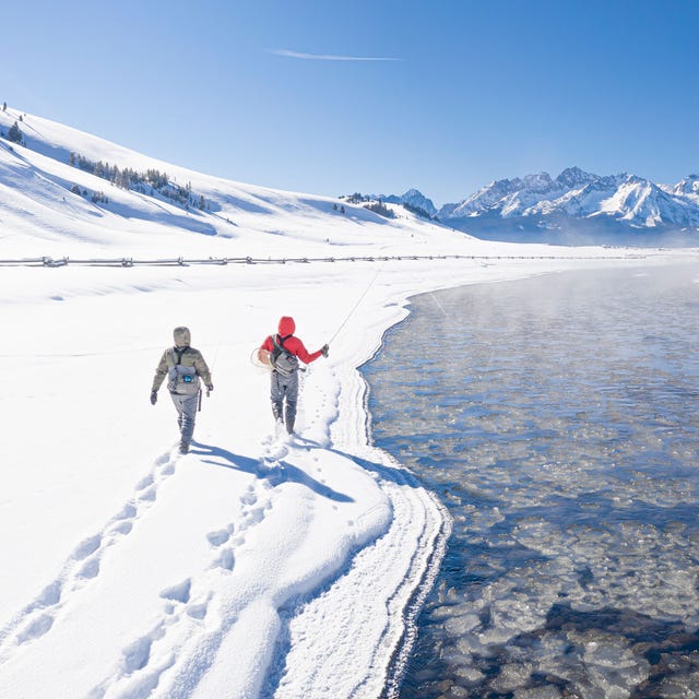 people walking on a snowy mountain with orvis fishing gear