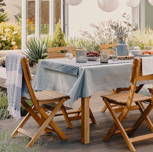 outdoor table and chairs set for a dinner party with paper lanterns