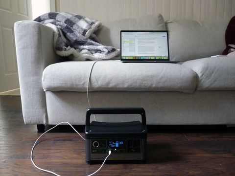 Goal Zero Yeti 500X charging a computer that is sitting on a couch
