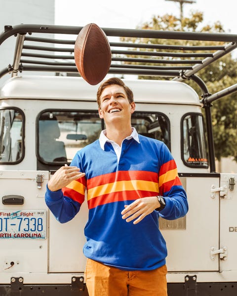 man wearing huckberry ulysses rugby shirt while tossing a football in the air