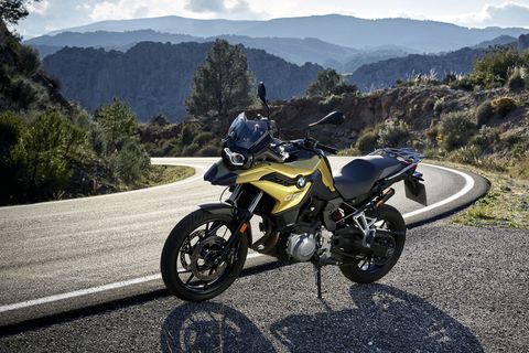 bmw f 750 gs parked on the road with mountains in the background