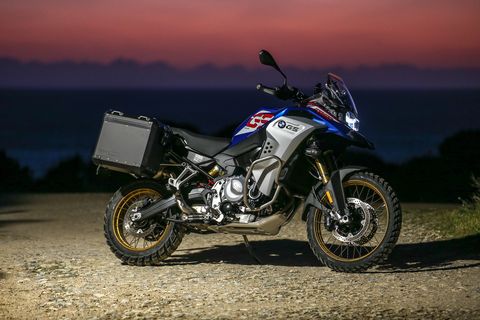 bmw f 850 gs parked in dirt with a sunset in the background
