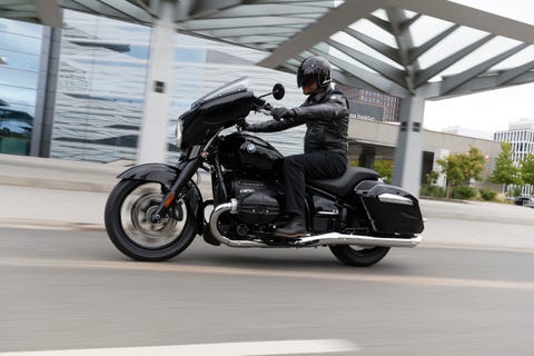 bmw r18 riding on the street in germany with an arty looking building in the background