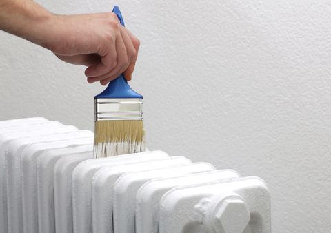 painting old white radiator with brush