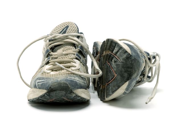 pair of old used running shoes isolated on white background