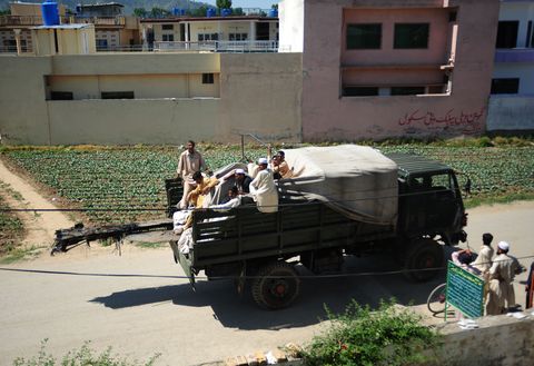 les soldats de l'armée pakistanaise déplacent des morceaux d'un