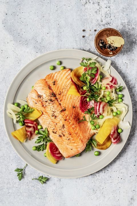 Pan fried salmon with vegetables on gray background