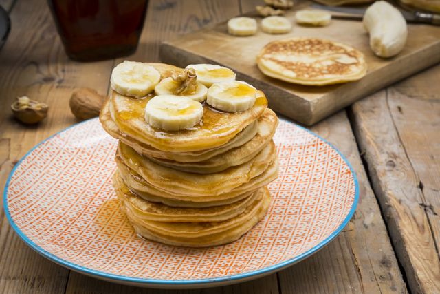 pancakes with walnut, maple syrup and banana on plate