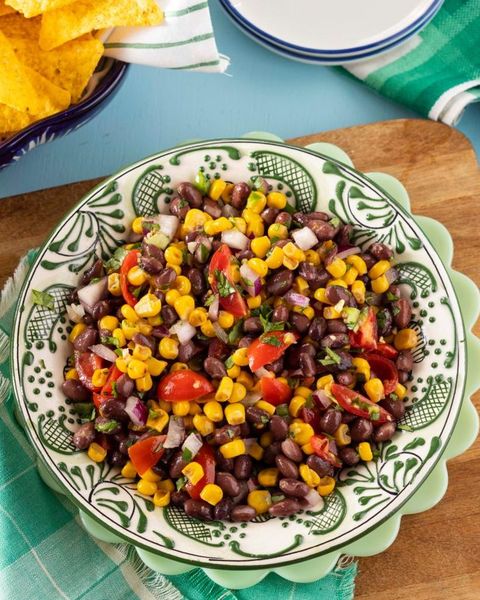 party dip recipes corn black bean salsa in green and white bowl with chips in back