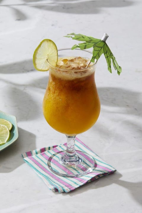 passion fruit mai tai tropical cocktail  with a mini umbrella and slice of lime