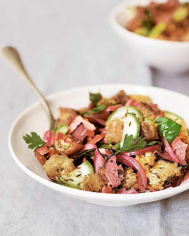 pastrami and rye panzanella in a white bowl on a light gray tablecloth