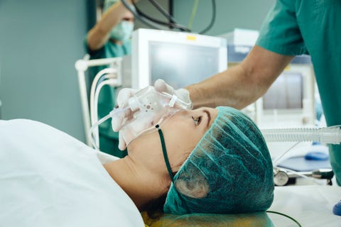 Patient with a respiratory mask on operating table