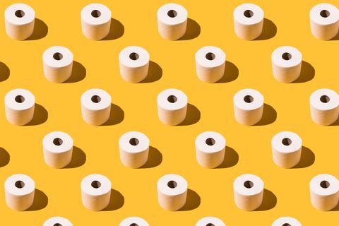 pattern of white toilet paper rolls on yellow background concept of going to the bathroom, cleaning and pooping and peeing